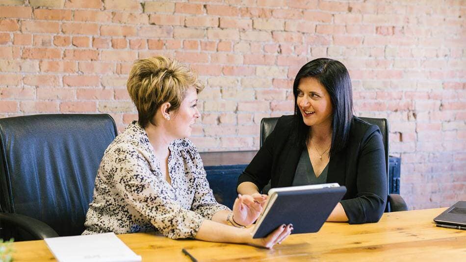 Two women talking in office environment